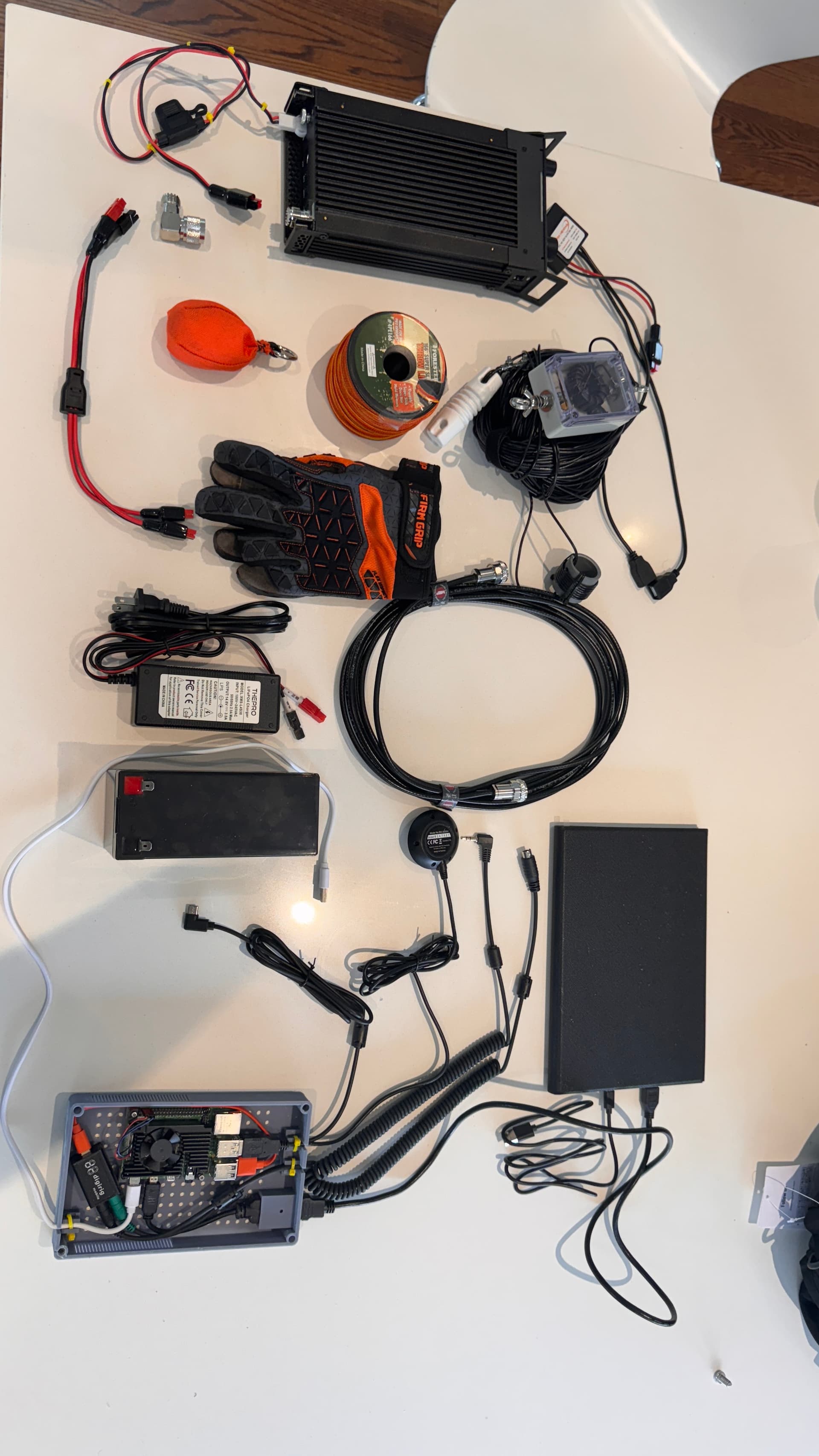 Early radio components on a workbench — Raspberry Pi, small battery, GPS module, and amateur radio